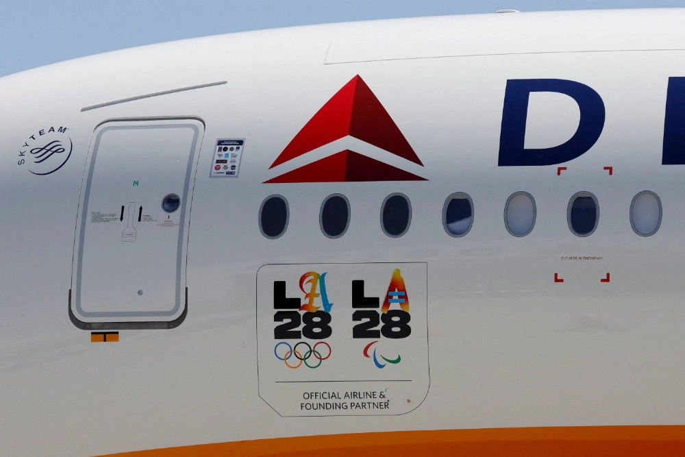 LA28 logos are seen on a Delta Airlines jet carrying American athletes and officials and the Olympic flag as it arrives in Los Angeles, on August 12, 2024.  LA28 logos are seen on a Delta Airlines jet carrying American athletes and officials and the Olympic flag as it arrives in Los Angeles, on August 12, 2024.