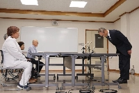 Hisaaki Ikeuchi (right), chief of Shiga Prefectural Police department, bows in apology to former nurse Mika Nishiyama (left) during their meeting in Hikone, Shiga Prefecture, on Thursday.