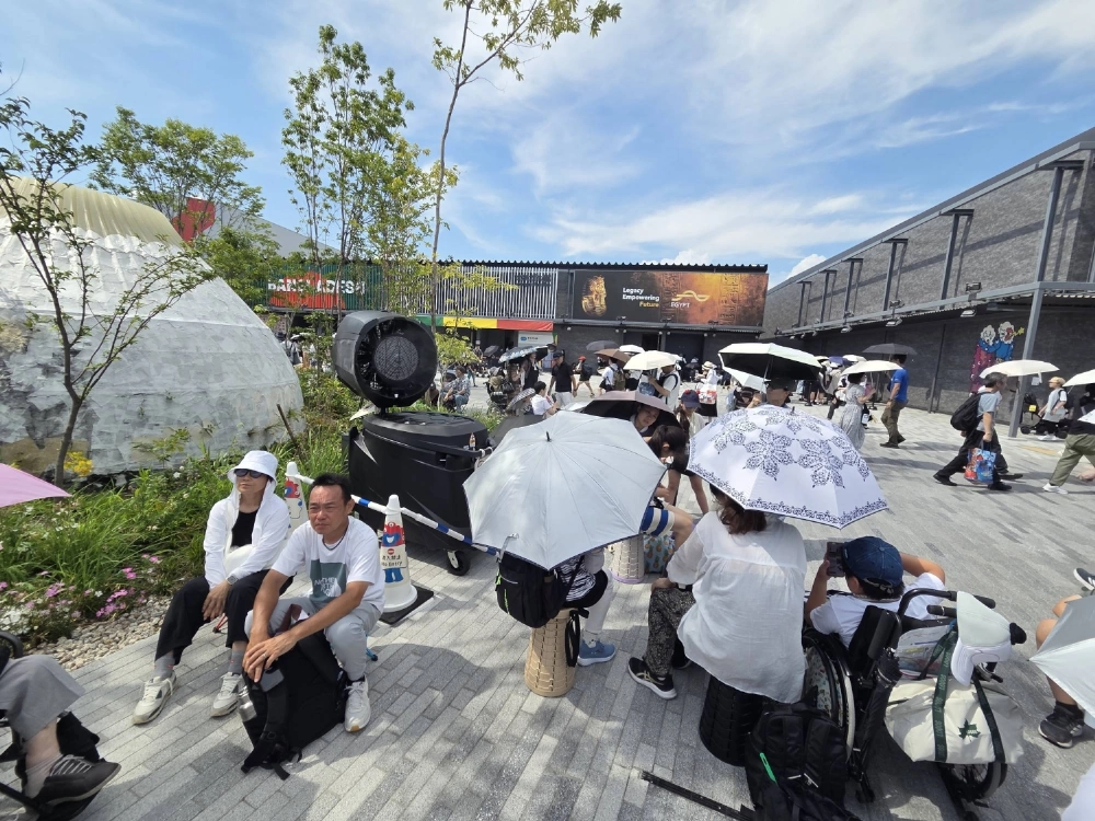 People huddle near a large fan blowing icy-cold mist at the Osaka Expo on July 12. Amid Japan's relentless summer heat, organizes have put myriad measures in place in order to keep guests safe.  People huddle near a large fan blowing icy-cold mist at the Osaka Expo on July 12. Amid Japan's relentless summer heat, organizes have put myriad measures in place in order to keep guests safe.