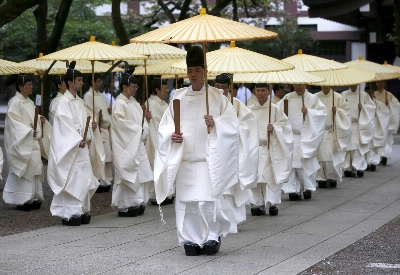 Shinto priests holding traditional umbrellas walk to the main shrine for a ritual to cleanse themselves during the annual Spring Festival at Yasukuni Shrine in Tokyo in April 2016. Shinto priests holding traditional umbrellas walk to the main shrine for a ritual to cleanse themselves during the annual Spring Festival at Yasukuni Shrine in Tokyo in April 2016.