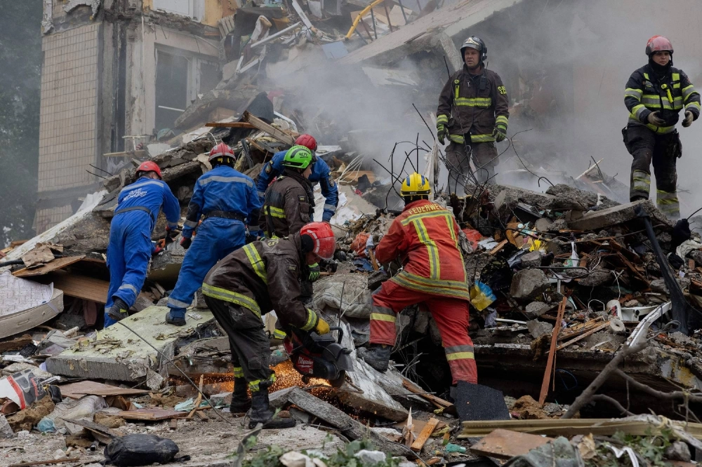 Rescuers clear debris as they work at the site of a destroyed residential building following a Russian air attack in Kyiv on July 31. Rescuers clear debris as they work at the site of a destroyed residential building following a Russian air attack in Kyiv on July 31.