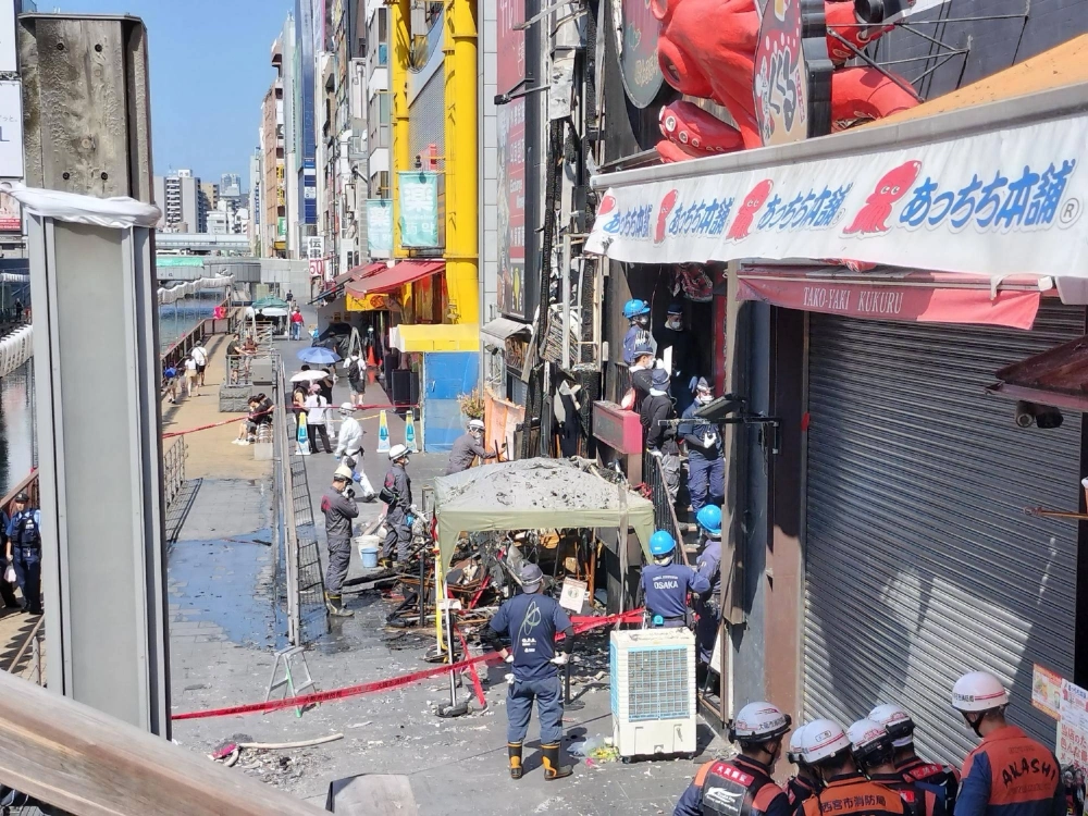 Authorities on Tuesday inspect two buildings that were burnt in a fire in the city of Osaka the previous day. Authorities on Tuesday inspect two buildings that were burnt in a fire in the city of Osaka the previous day.