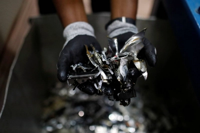 A worker displays a handful of shredded hard drive pieces for e-waste processing at a facility in Festac, Nigeria, in 2020.  A worker displays a handful of shredded hard drive pieces for e-waste processing at a facility in Festac, Nigeria, in 2020.