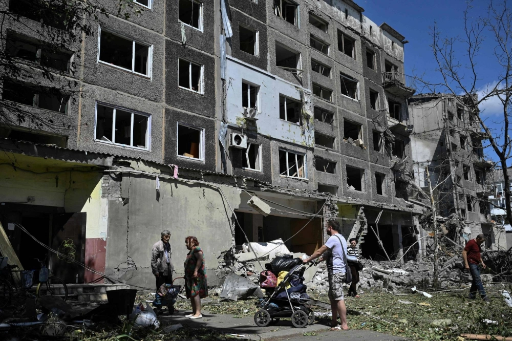 Local residents carry their belongings out of a heavily damaged residential building following a Russian strike in the town of Bilozerske, in Ukraine's Donetsk region, on Aug. 12. Local residents carry their belongings out of a heavily damaged residential building following a Russian strike in the town of Bilozerske, in Ukraine's Donetsk region, on Aug. 12.