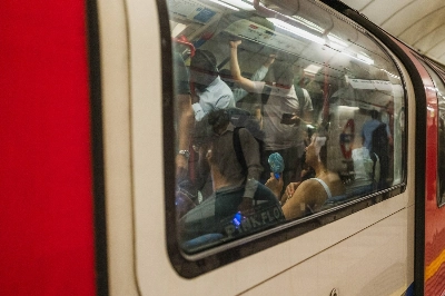 A commuter uses a portable fan on an underground train at rush hour during a heat wave in the City of London financial district. A commuter uses a portable fan on an underground train at rush hour during a heat wave in the City of London financial district.
