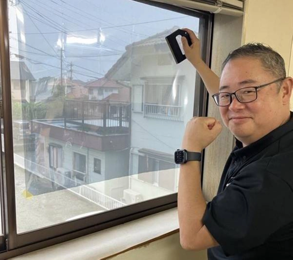 A-Style President Kenichiro Kawakami applies a heat-shielding film to a window. A-Style President Kenichiro Kawakami applies a heat-shielding film to a window.