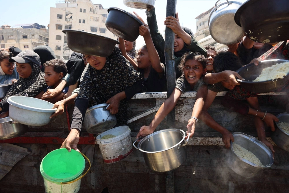 Palestinian women and girls elbow their way to receive cooked rice from charity kitchen in Gaza City, in the Gaza Strip, on Saturday. Palestinian women and girls elbow their way to receive cooked rice from charity kitchen in Gaza City, in the Gaza Strip, on Saturday.
