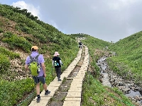 Hikers on a trail in Hakuba, Nagano Prefecture. As extreme heat continues to grip Japan, a tectonic shift may be underway in the nation’s summer tourism scene as more people gravitate toward cooler destinations. | TOMOKO OTAKE