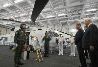 Defense Minister Gen Nakatani (right) and Prime Minister Shigeru Ishiba (second from right) inspect the Maritime Self-Defense Force helicopter carrier Kaga and receive an explanation about the SH-60K patrol helicopter in the hangar at the MSDF's Yokosuka base in Kanagawa Prefecture on Saturday. | POOL / VIA JIJI