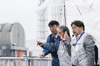 Chief Cabinet Secretary Yoshimasa Hayashi (right) inspects an interim storage facility where soil from decontamination work is temporarily stored, at the Fukushima No. 1 nuclear power plant in Fukushima Prefecture on Aug. 10. | POOL / VIA JIJI