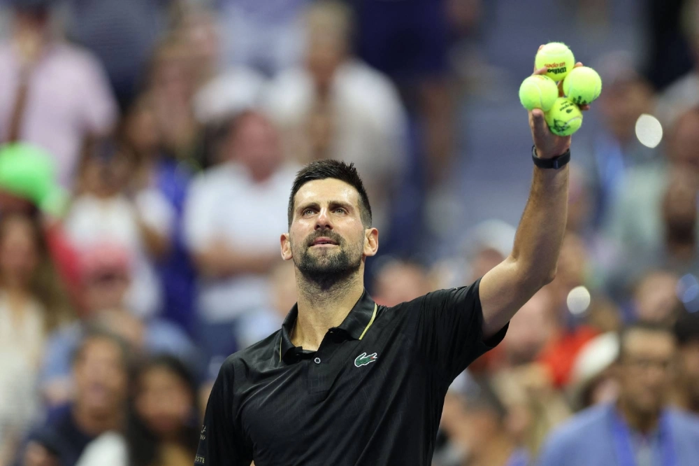 Novak Djokovic prepares to throw signed balls into the crowd after beating Learner Tien in the first round of the U.S. Open in New York on Sunday.  Novak Djokovic prepares to throw signed balls into the crowd after beating Learner Tien in the first round of the U.S. Open in New York on Sunday.