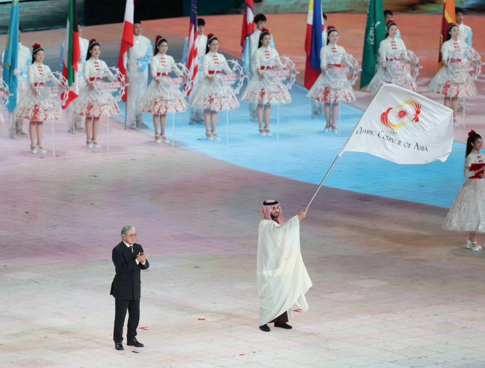 The Saudi Arabia delegate waves the OCA flag during the closing ceremony of the Asian Winter Games in Harbin, China, on Feb. 14. The Saudi Arabia delegate waves the OCA flag during the closing ceremony of the Asian Winter Games in Harbin, China, on Feb. 14.
