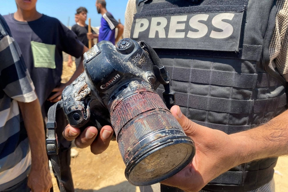 A journalist holds the blood-covered camera of Palestinian photojournalist Mariam Dagga, who was killed during an Israeli strike on Nasser hospital in Khan Younis in the southern Gaza Strip, during her funeral on Monday. A journalist holds the blood-covered camera of Palestinian photojournalist Mariam Dagga, who was killed during an Israeli strike on Nasser hospital in Khan Younis in the southern Gaza Strip, during her funeral on Monday.