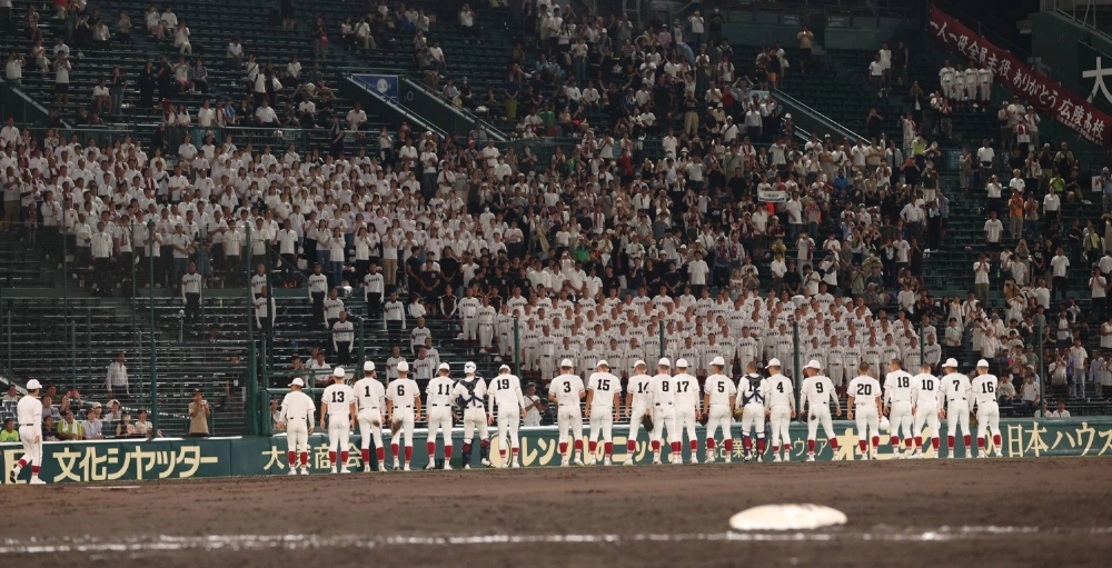 Koryo High School players greet their cheering section after beating Hokkaido’s Asahikawa Shiho in the first round of Summer Koshien on Aug. 7. The school withdrew three days later as a bullying scandal enveloped the team.   Koryo High School players greet their cheering section after beating Hokkaido’s Asahikawa Shiho in the first round of Summer Koshien on Aug. 7. The school withdrew three days later as a bullying scandal enveloped the team.