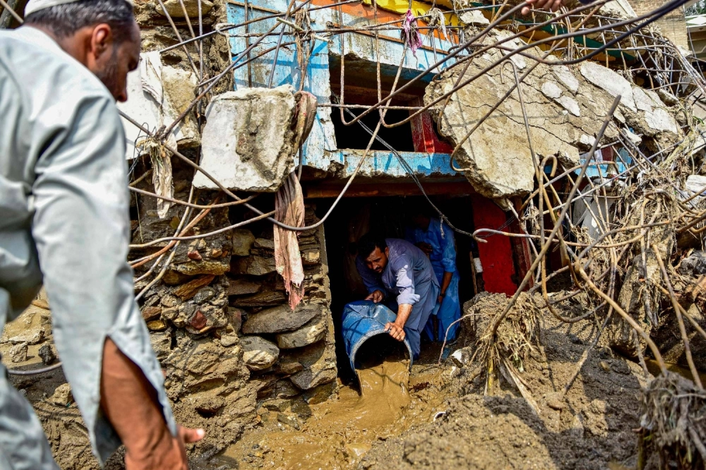 A resident removes sludge from his damaged house a day after flash floods in the Buner district of mountainous Khyber Pakhtunkhwa province on Aug. 16. A resident removes sludge from his damaged house a day after flash floods in the Buner district of mountainous Khyber Pakhtunkhwa province on Aug. 16.