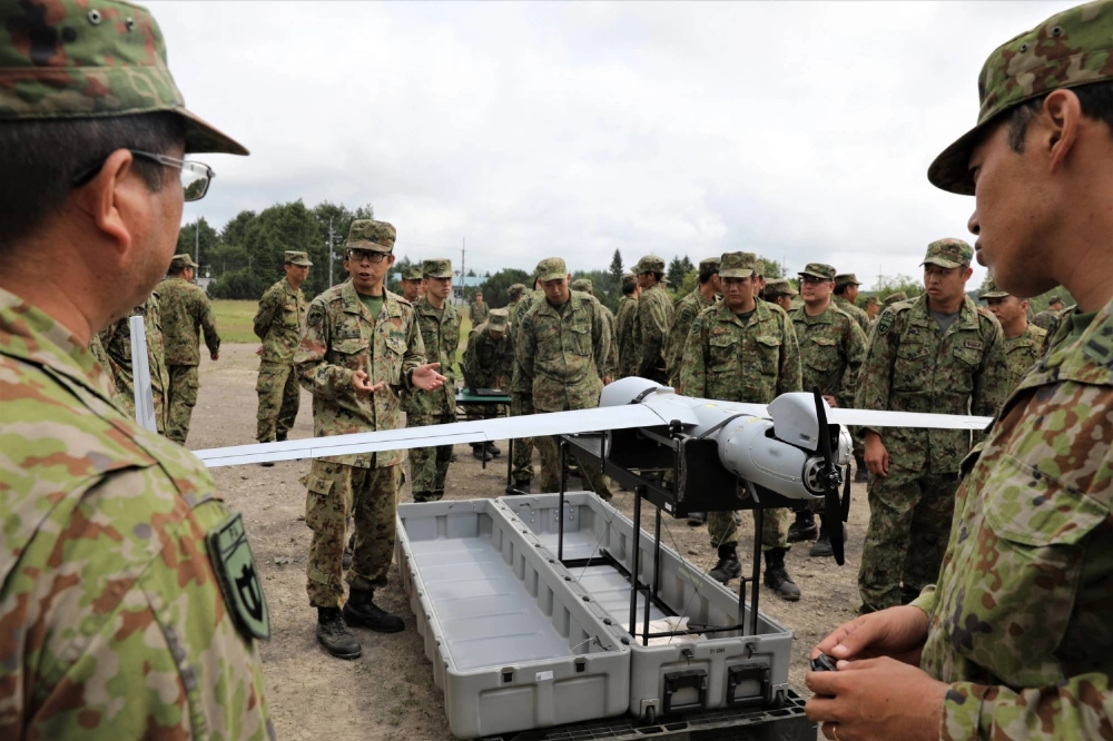 A group of Ground Self-Defense Force service members discuss drone operations and capabilities at a joint static display during the Orient Shield 24 opening ceremony at the Yausubetsu Training Area in Hokkaido in July last year. A group of Ground Self-Defense Force service members discuss drone operations and capabilities at a joint static display during the Orient Shield 24 opening ceremony at the Yausubetsu Training Area in Hokkaido in July last year.