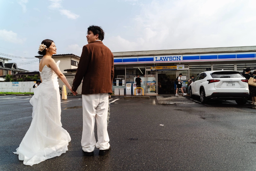 A couple poses for a wedding photo in front of a Lawson in the town of Kawaguchiko, Yamanashi Prefecture, on Aug. 25. A couple poses for a wedding photo in front of a Lawson in the town of Kawaguchiko, Yamanashi Prefecture, on Aug. 25.