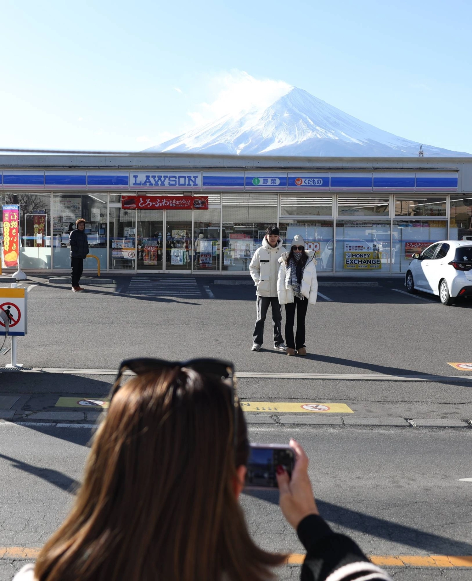 Tourists take photos of the Fujikawaguchiko Lawson and Mount Fuji in January. Tourists take photos of the Fujikawaguchiko Lawson and Mount Fuji in January.
