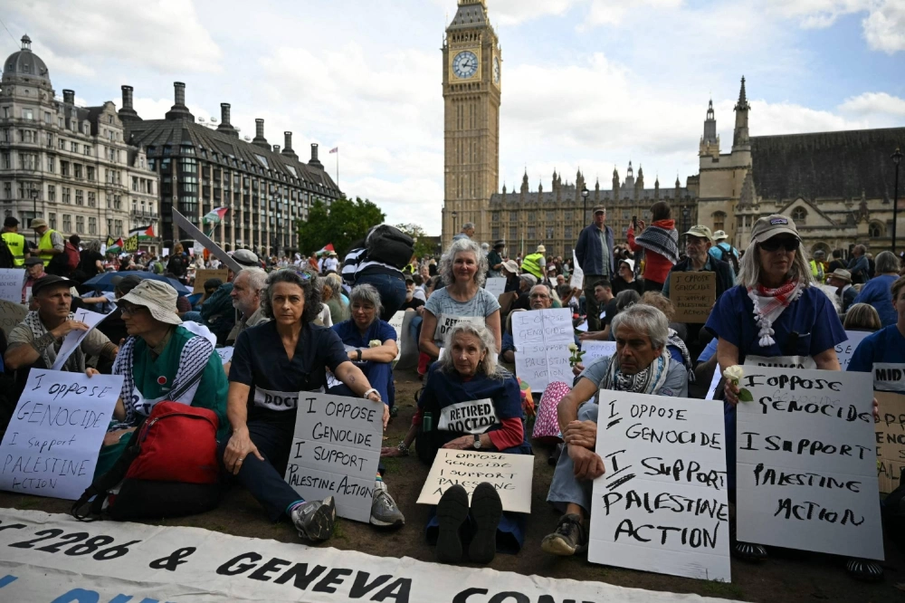 Protesters sit down with their placards in support of Palestine Action at a "Lift The Ban" demonstration in support of the proscribed group Palestine Action, calling for the recently imposed ban to be lifted, in Parliament Square, central London, on Saturday. Protesters sit down with their placards in support of Palestine Action at a "Lift The Ban" demonstration in support of the proscribed group Palestine Action, calling for the recently imposed ban to be lifted, in Parliament Square, central London, on Saturday.