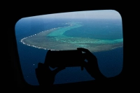 A reporter records video over Scarborough Shoal in the disputed South China Sea in February 2024.  | AFP-JIJI