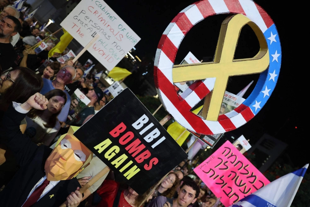 A protester wearing a mask representing U.S. President Donald Trump carries a sign during a demonstration organized by the families of Israelis held hostage by Palestinian militants in the Gaza Strip, to call for their release and for a ceasefire in the war in Gaza, in Tel Aviv on Saturday. A protester wearing a mask representing U.S. President Donald Trump carries a sign during a demonstration organized by the families of Israelis held hostage by Palestinian militants in the Gaza Strip, to call for their release and for a ceasefire in the war in Gaza, in Tel Aviv on Saturday.