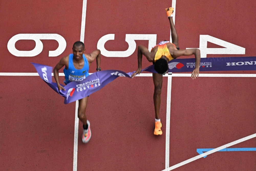 Germany's Amanal Petros (R) falls as he crosses the finish line behind Tanzania's athlete Alphonce Felix Simbu (L) in the men's marathon final during the World Athletics Championships in Tokyo on Monday. Germany's Amanal Petros (R) falls as he crosses the finish line behind Tanzania's athlete Alphonce Felix Simbu (L) in the men's marathon final during the World Athletics Championships in Tokyo on Monday.