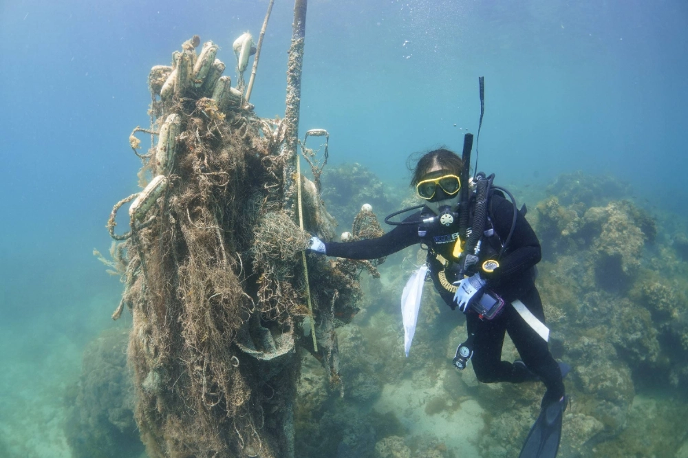 A huge piece of plastic waste is pulled up from the waters near Tatara Island, Nagasaki Prefecture, on July 10. A huge piece of plastic waste is pulled up from the waters near Tatara Island, Nagasaki Prefecture, on July 10.