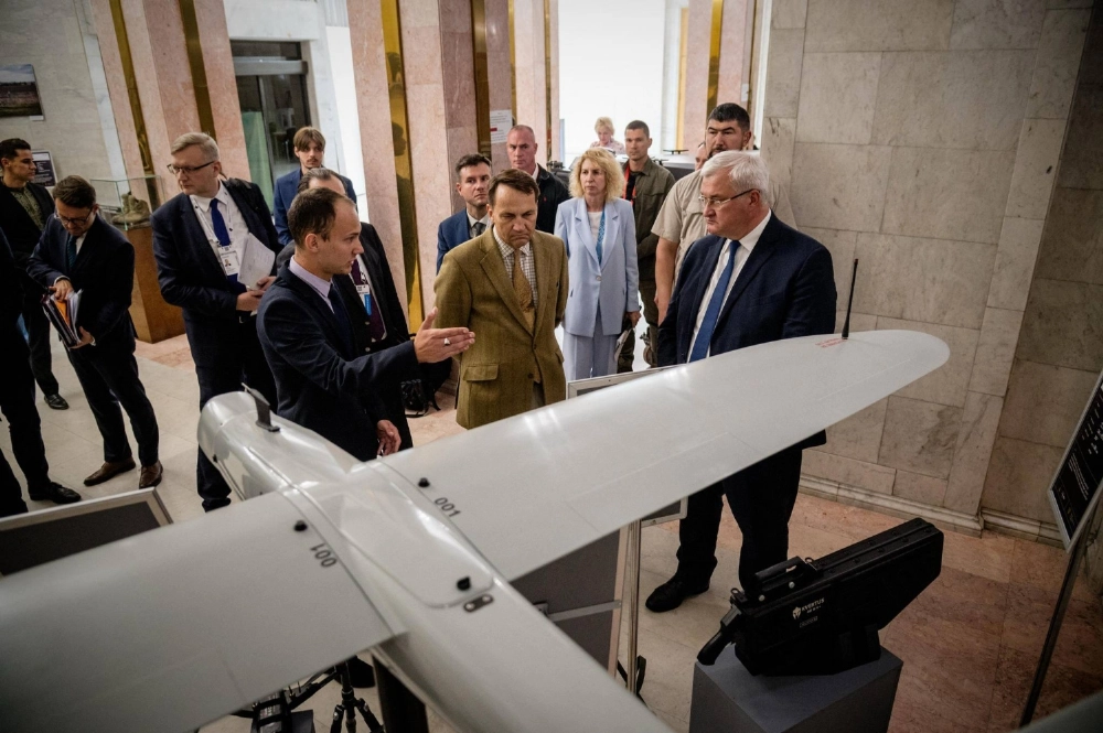 Ukrainan Foreign Minister Andriy Sybiga (right) and his Polish counterpart Radoslaw Sikorski (center) look at drones as they visit an exhibition showcasing Ukrainian unmanned vehicles in Kyiv on Sept. 12. Ukrainan Foreign Minister Andriy Sybiga (right) and his Polish counterpart Radoslaw Sikorski (center) look at drones as they visit an exhibition showcasing Ukrainian unmanned vehicles in Kyiv on Sept. 12.