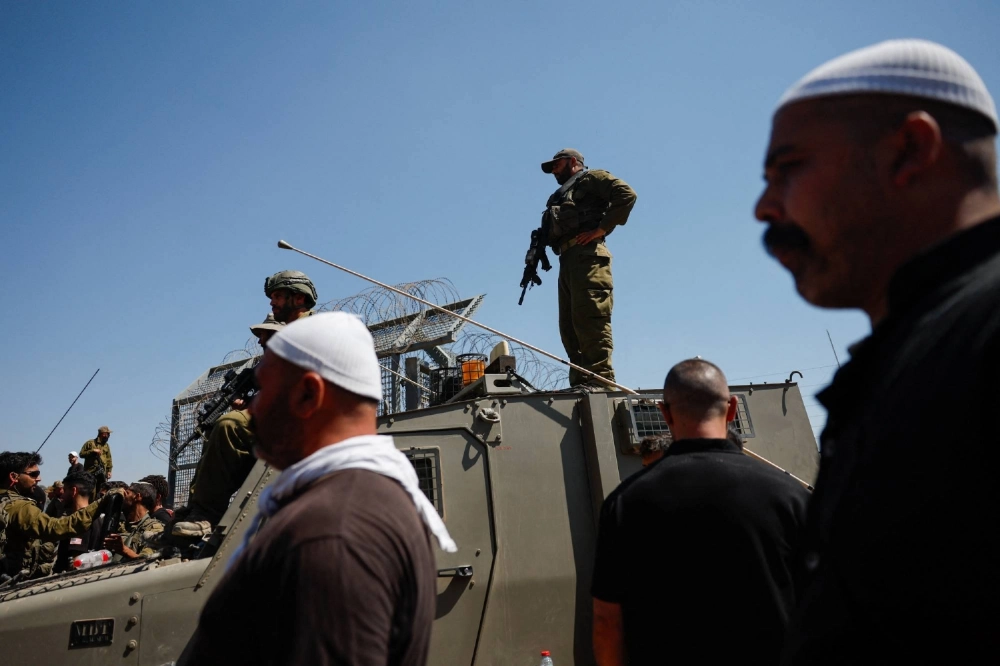 Israeli Border Police stand as Israeli Druze cross the border to check on their family members in Syria, amid the ongoing conflict in the Druze areas in Syria, in Majdal Shams, near the ceasefire line between the Israeli-occupied Golan Heights and Syria on July 16. Israeli Border Police stand as Israeli Druze cross the border to check on their family members in Syria, amid the ongoing conflict in the Druze areas in Syria, in Majdal Shams, near the ceasefire line between the Israeli-occupied Golan Heights and Syria on July 16.