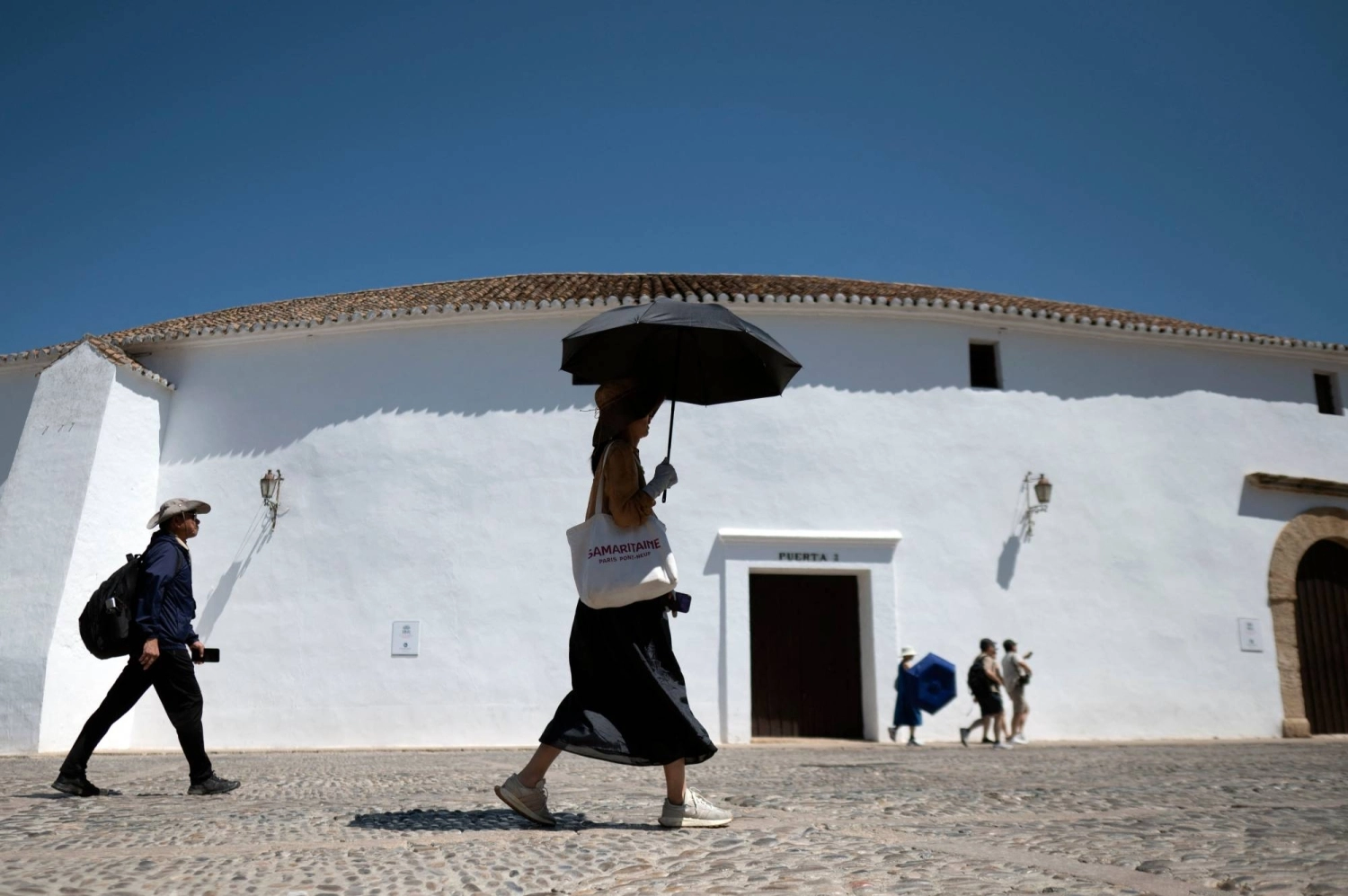 A woman shields herself from the sun with an umbrella in Ronda, southern Spain, during the first heatwave of the summer, on July 2. A woman shields herself from the sun with an umbrella in Ronda, southern Spain, during the first heatwave of the summer, on July 2.