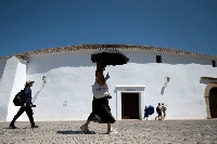 A woman shields herself from the sun with an umbrella in Ronda, southern Spain, during the first heatwave of the summer, on July 2. | AFP-JIJI