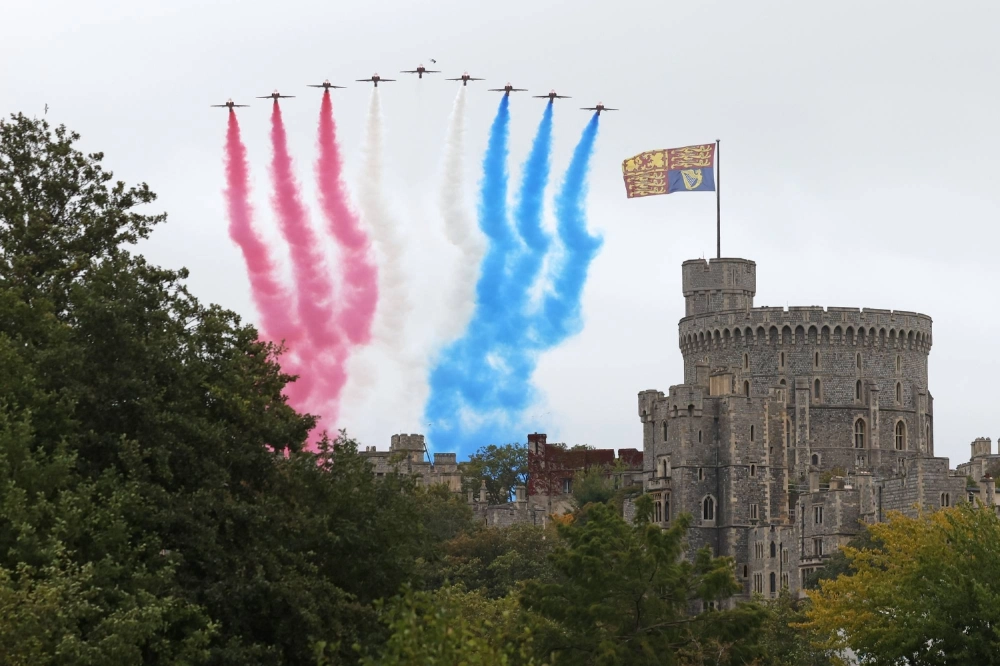 The RAF Red Arrows perform a flyover at Windsor Castle in the U.K. on Wednesday. The RAF Red Arrows perform a flyover at Windsor Castle in the U.K. on Wednesday.