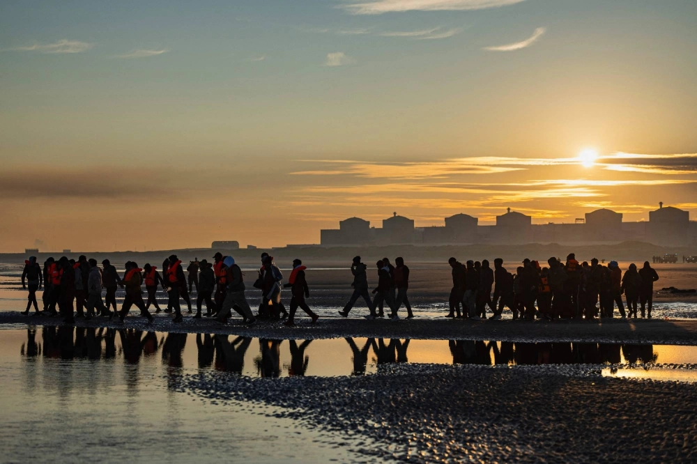 Migrants wade into the sea to try to board smugglers' boats in an attempt to cross the English Channel off the beach of Gravelines, northern France, on Saturday. Migrants wade into the sea to try to board smugglers' boats in an attempt to cross the English Channel off the beach of Gravelines, northern France, on Saturday.