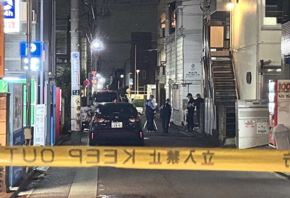 Tokyo police officers investigate on Tuesday the site in Machida, Tokyo, where a 76-year-old woman was fatally stabbed. Tokyo police officers investigate on Tuesday the site in Machida, Tokyo, where a 76-year-old woman was fatally stabbed.