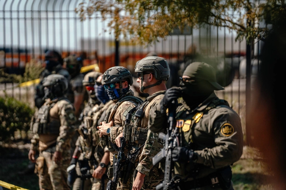 Federal law enforcement officers line up in the Brighton Park neighborhood in Chicago on Saturday. Federal law enforcement officers line up in the Brighton Park neighborhood in Chicago on Saturday.