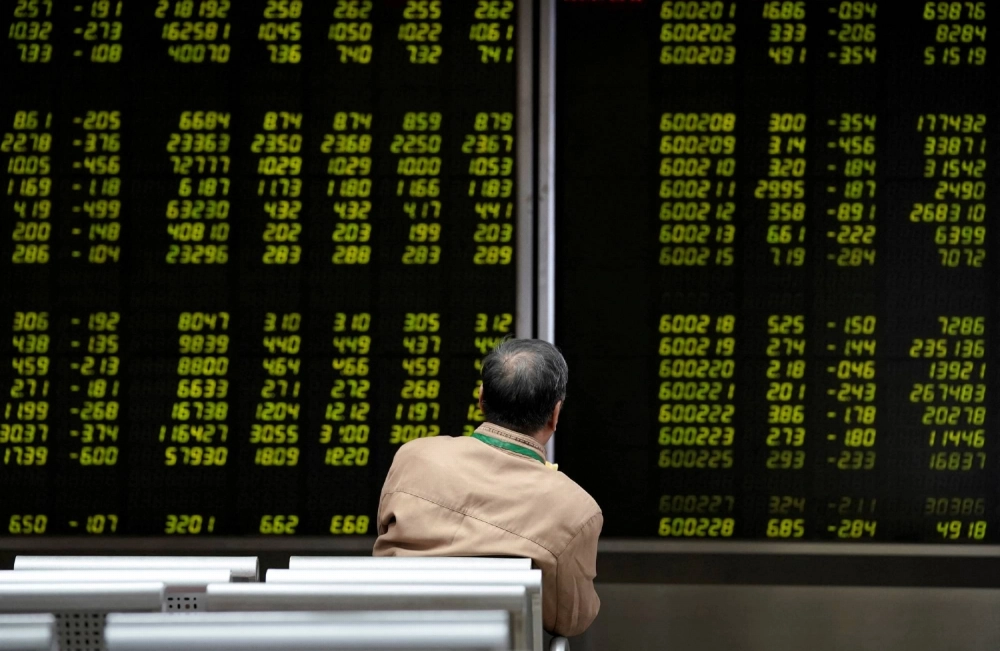 An investor watches a board showing stock information at a brokerage office in Beijing. An investor watches a board showing stock information at a brokerage office in Beijing.