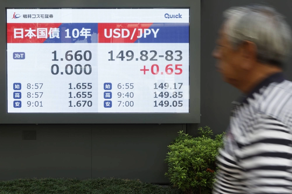 A screen displays Japan's 10-year government bonds and the rate of the yen against the dollar outside a securities firm in Tokyo on Monday. A screen displays Japan's 10-year government bonds and the rate of the yen against the dollar outside a securities firm in Tokyo on Monday.