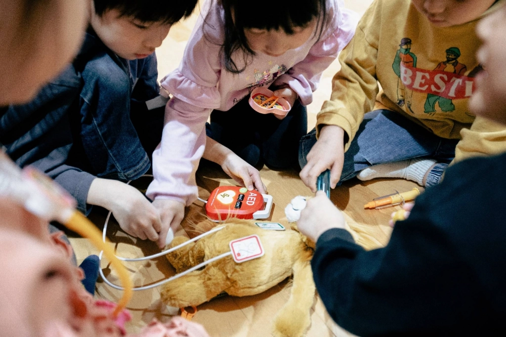 Children play with the AED-themed Toy Cocoro. Children play with the AED-themed Toy Cocoro.