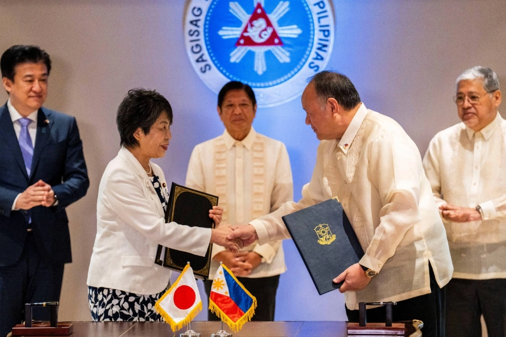 Japan's then-foreign minister, Yoko Kamikawa (left), and Philippine defense chief Gilberto Teodoro shake hands after signing a Reciprocal Access Agreement at the Malacanang Palace in Manila in July last year. Japan's then-foreign minister, Yoko Kamikawa (left), and Philippine defense chief Gilberto Teodoro shake hands after signing a Reciprocal Access Agreement at the Malacanang Palace in Manila in July last year.