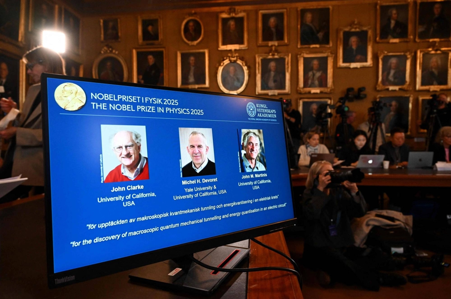 Photos of John Clarke, Michel Devoret and John Martinis are displayed on a screen during a news conference on the awarding of the 2025 Nobel Prize in physics at the Royal Swedish Academy of Sciences in Stockholm, Sweden, on Tuesday. Photos of John Clarke, Michel Devoret and John Martinis are displayed on a screen during a news conference on the awarding of the 2025 Nobel Prize in physics at the Royal Swedish Academy of Sciences in Stockholm, Sweden, on Tuesday.