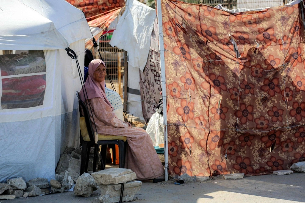 A woman sits at a camp for people displaced by war in northern Nuseirat, in the central Gaza Strip, on Tuesday.  A woman sits at a camp for people displaced by war in northern Nuseirat, in the central Gaza Strip, on Tuesday.