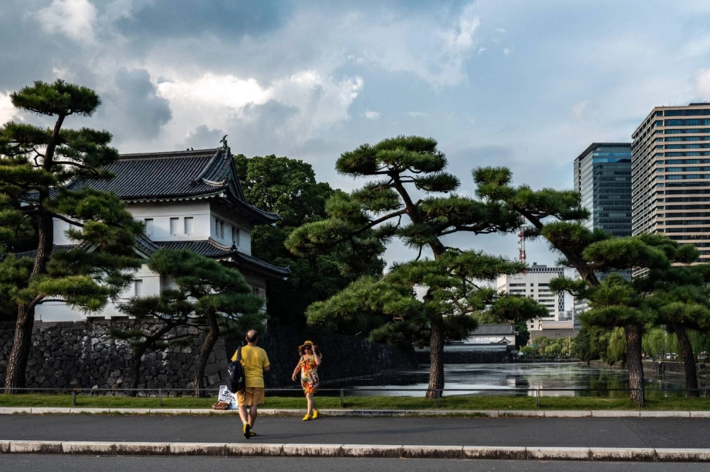 Tourists in front of the Imperial Palace in Tokyo on Sept. 10. Increased spending by foreign visitors and brisk home sales are behind an improvement in economy-watcher sentiment, a survey has shown. Tourists in front of the Imperial Palace in Tokyo on Sept. 10. Increased spending by foreign visitors and brisk home sales are behind an improvement in economy-watcher sentiment, a survey has shown.