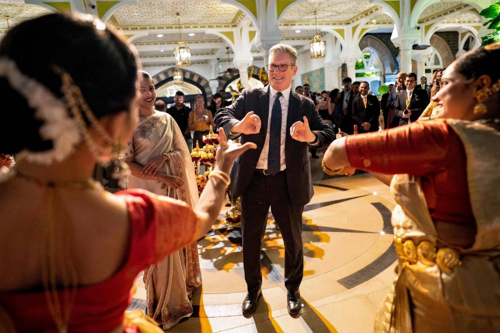 British Prime Minister Keir Starmer (center) gestures as he meets Indian traditional dancers during a ceremony for the upcoming Diwali festival in Mumbai on Wednesday. British Prime Minister Keir Starmer (center) gestures as he meets Indian traditional dancers during a ceremony for the upcoming Diwali festival in Mumbai on Wednesday.