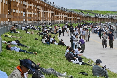 Visitors lounge on the grassy hill on the top of the Grand Ring during the 2025 Osaka Expo in the city of Osaka in May. Visitors lounge on the grassy hill on the top of the Grand Ring during the 2025 Osaka Expo in the city of Osaka in May.
