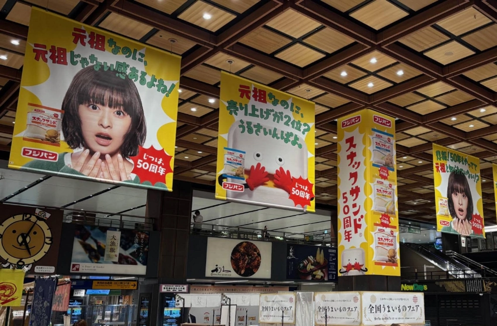 Large self-deprecating advertisements for Fuji Baking’s Snack Sand products at JR Sendai Station Large self-deprecating advertisements for Fuji Baking’s Snack Sand products at JR Sendai Station