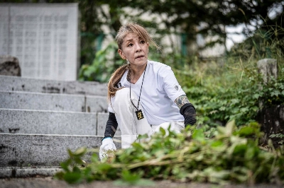 Retired yakuza Mako Nishimura sorts fallen leaves during a clean-up activity at the Gifu Gokoku shrine in Gifu Prefecture on Sept. 28. Retired yakuza Mako Nishimura sorts fallen leaves during a clean-up activity at the Gifu Gokoku shrine in Gifu Prefecture on Sept. 28.