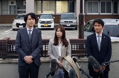 Riho Fukuyama (center) and her husband Yoshiki Fukuyama (left) speak to the media with their lawyer (right) outside the Toyama District Court in Toyama on Tuesday. Riho Fukuyama (center) and her husband Yoshiki Fukuyama (left) speak to the media with their lawyer (right) outside the Toyama District Court in Toyama on Tuesday.