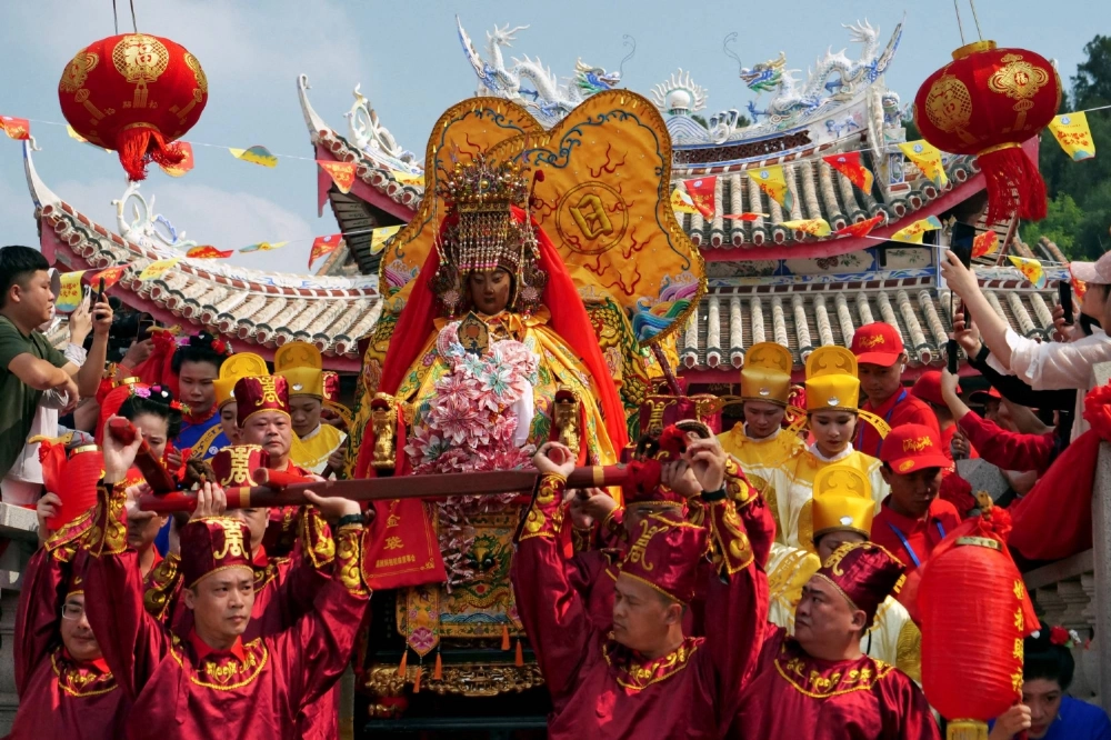 Pilgrims carry a sedan chair holding a statue of the sea goddess Mazu out of a temple during a pilgrimage on Meizhou island, Fujian province, China on Oct. 11, 2024.  Pilgrims carry a sedan chair holding a statue of the sea goddess Mazu out of a temple during a pilgrimage on Meizhou island, Fujian province, China on Oct. 11, 2024.