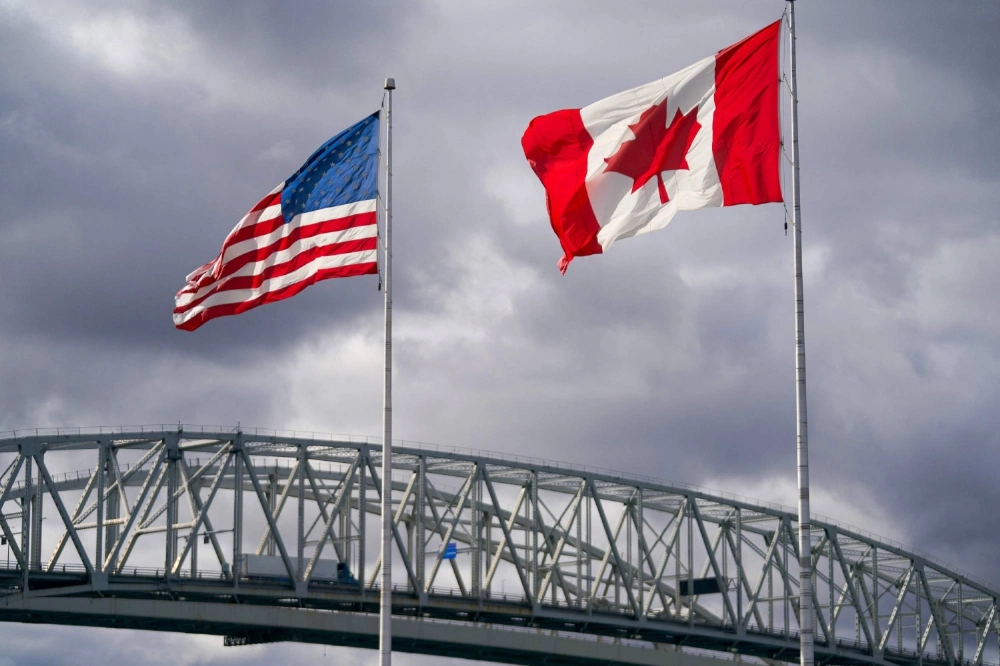 U.S. and Canadian flags flutter next to the Blue Water Bridge border crossing in Point Edward, Ontario, on Friday. U.S. and Canadian flags flutter next to the Blue Water Bridge border crossing in Point Edward, Ontario, on Friday.