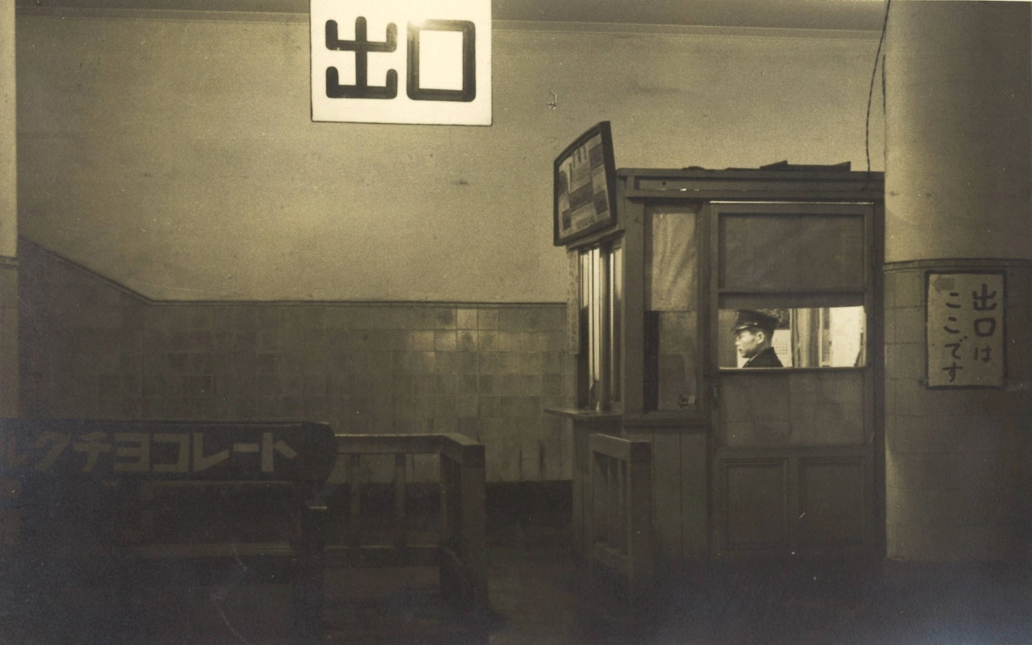 An old photo of Hakubutsukan-Dobutsuen Station shows a railway employee in a ticket booth at the exit.  An old photo of Hakubutsukan-Dobutsuen Station shows a railway employee in a ticket booth at the exit.
